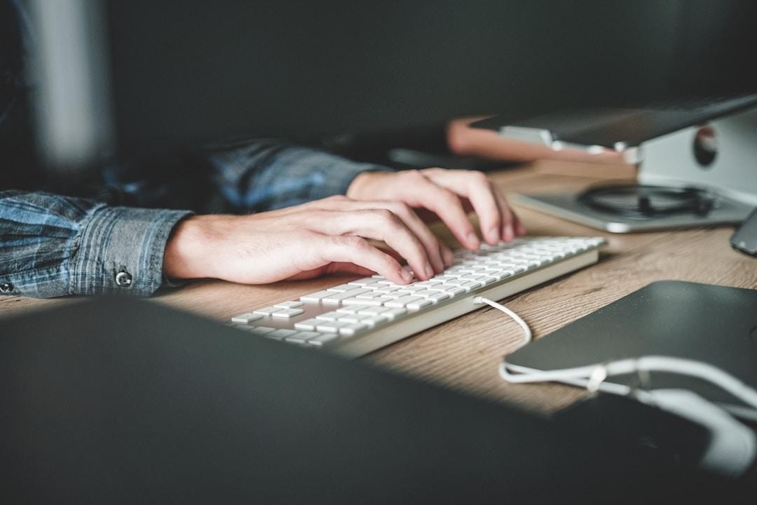 Individual at a desk typing on a keyboard, engaged in newsletter software for content creation.