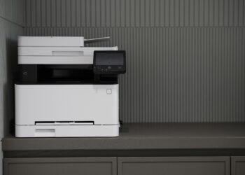 An office space with an abandoned fax machine and physical documents replaced by online fax services.